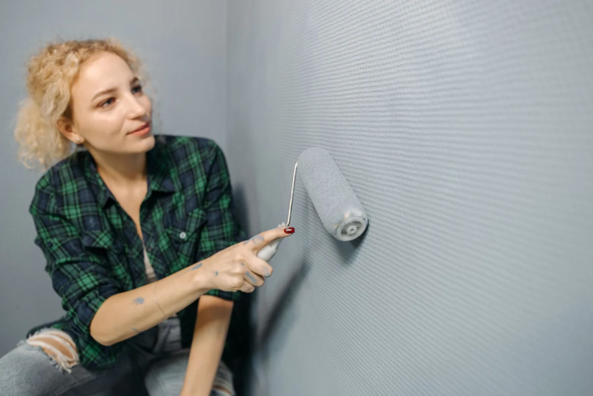 Wand van een woonkamer wordt met een roller geschilderd